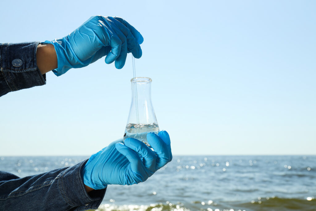 a test tube with river water in hands in blue glov 2023 11 27 05 25 13 utc